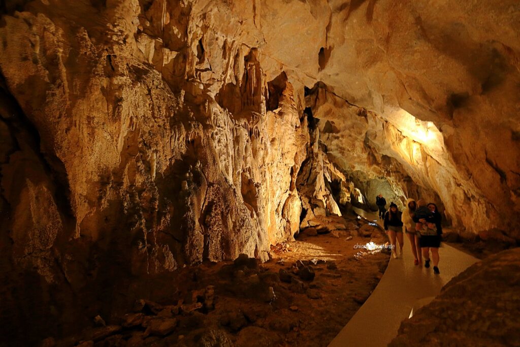 Interno della Grotta Superiore di Cerovac, con stalattiti illuminate e visitatori che percorrono il camminamento durante il tour guidato.